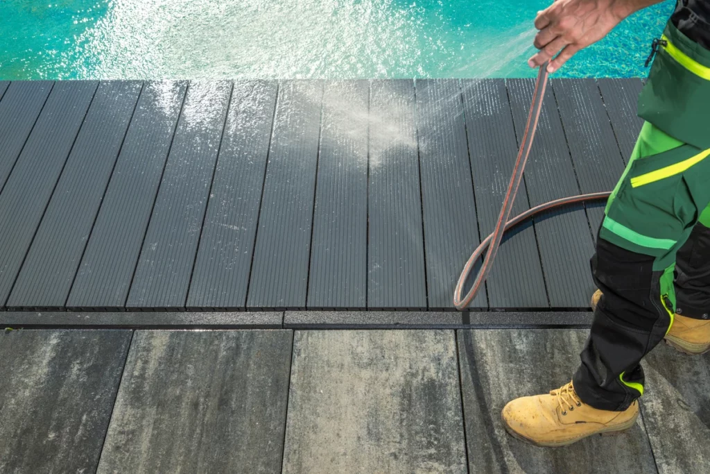 A man providing soft washing for exterior cleaning services on a deck